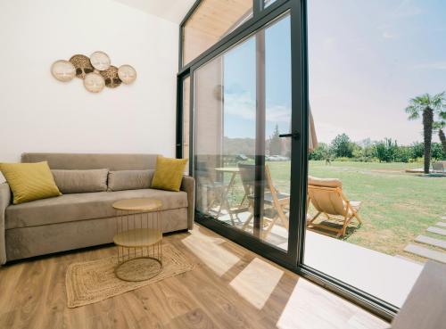 a living room with a couch and a large window at Tommys Village in Ulcinj