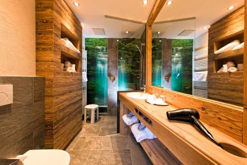 a bathroom with a sink and a mirror at Hotel Truyenhof in Ried im Oberinntal