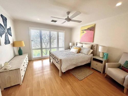 a bedroom with a bed and a couch and a window at Rose Villa - Port Willunga in Port Willunga