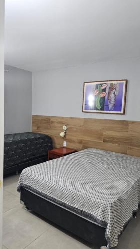 a bedroom with a bed and a picture on the wall at Hotel Luupi Esmeralda Apto 159 - Rio Quente GO in Rio Quente