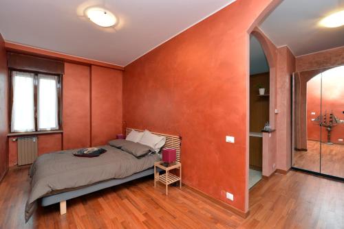 アルバにあるB&B アルバ チェントロのオレンジ色の壁のベッドルーム1室(ベッド1台付)