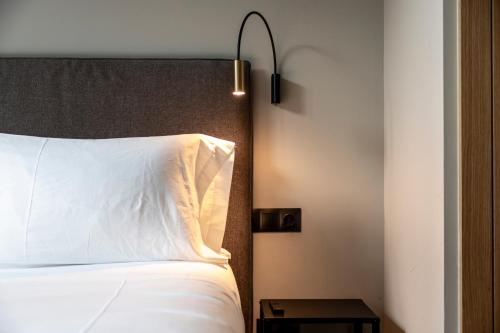 a bedroom with a bed with a white pillow and a lamp at Un diamante de montaña l A Pie De Pistas De Esquí - Gimnasio - Sauna - Piscina l 6Pax l by BonesVacances in El Tarter