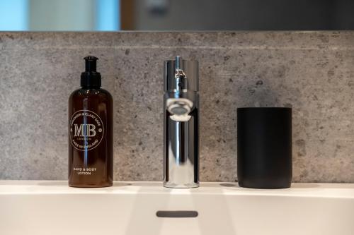 a bottle of soap sitting on a counter next to a soap dispenser at Un diamante de montaña l A Pie De Pistas De Esquí - Gimnasio - Sauna - Piscina l 6Pax l by BonesVacances in El Tarter