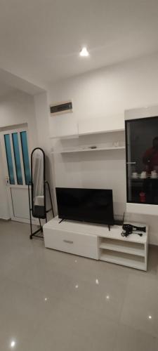 a living room with a flat screen tv and a chair at Kahari Apartments in Ulcinj