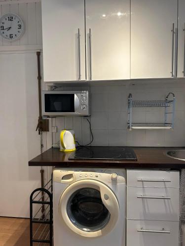 une cuisine avec un lave-linge et un micro-ondes dans l'établissement Idéal, à Vincennes