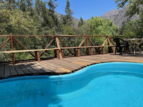a wooden bridge over a swimming pool on a deck at Cabaña Nido de Almas in San José de Maipo