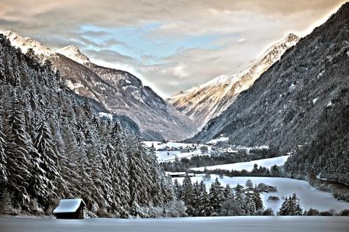 a snowy mountain valley with a small village and a lake at Hotel Truyenhof in Ried im Oberinntal