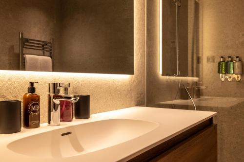 a bathroom with a white sink and a mirror at Un diamante de montaña l A Pie De Pistas - Gimnasio - Sauna - Piscina l 8Pax l by BonesVacances in El Tarter
