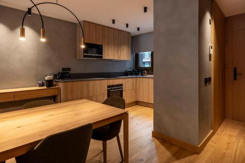 a kitchen with a wooden table and a dining room at Un diamante de montaña l A Pie De Pistas - Gimnasio - Sauna - Piscina l 8Pax l by BonesVacances in El Tarter