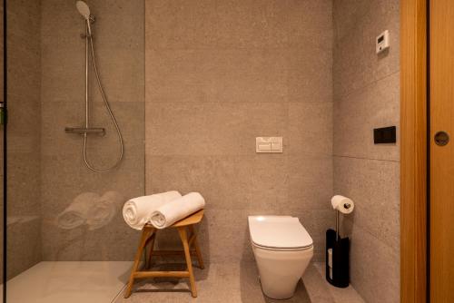 a bathroom with a shower and a toilet and a stool at Un diamante de montaña l A Pie De Pistas - Gimnasio - Sauna - Piscina l 8Pax l by BonesVacances in El Tarter