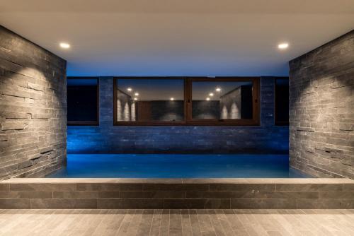 a swimming pool in a building with blue lighting at Un diamante de montaña l A Pie De Pistas - Gimnasio - Sauna - Piscina l 8Pax l by BonesVacances in El Tarter