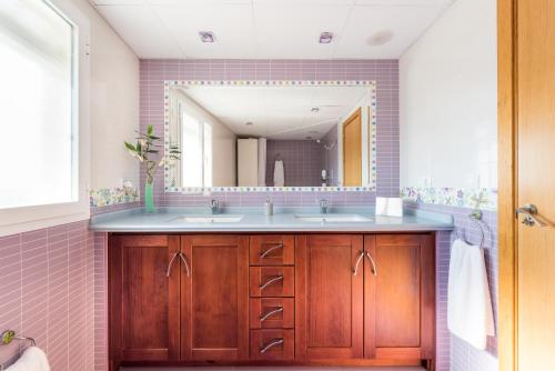 a bathroom with two sinks and a large mirror at Mirador del Guadalhorce in Alora