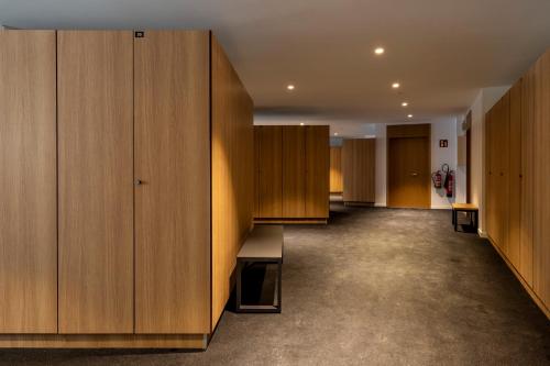 a hallway with wooden wardrobes and cabinets in a building at Un diamante de montaña l A Pie De Pistas - Gimnasio - Sauna - Piscina l 8Pax l by BonesVacances in El Tarter