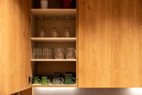 a cabinet with cups and glasses in it at Un diamante de montaña l A Pie De Pistas - Gimnasio - Sauna - Piscina l 8Pax l by BonesVacances in El Tarter