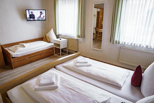 a hotel room with two beds and a mirror at Landgasthof Ochsen in Neresheim