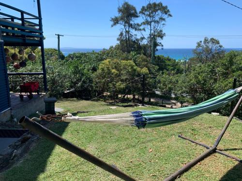 a hammock in a yard with the ocean in the background at Captain's Cove at Cylinder Beach in Point Lookout