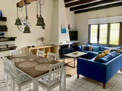 a living room with a table and a blue couch at Casa Mila in Moraira