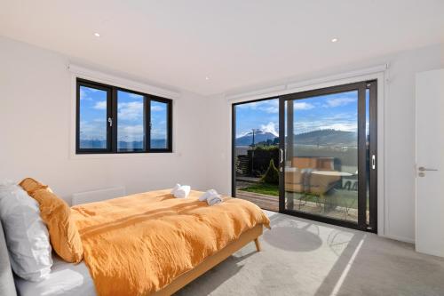 a bedroom with a bed and a large window at Anaka in Wanaka