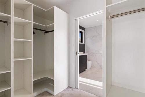 a white walk in closet with a glass door at Anaka in Wanaka