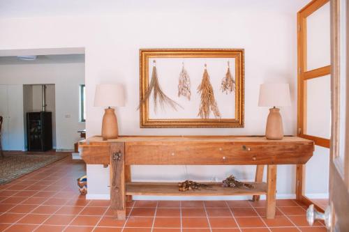 a table with two lamps and a picture on the wall at Just Like Home - Casa de Cimo de Vila in Vila Nova de Cerveira