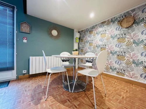 une salle à manger avec une table et des chaises blanches dans l'établissement Jolie petite maison en duplex, à Gravelines