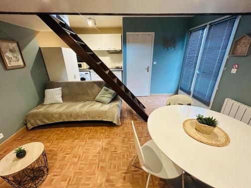 un salon avec une table et un canapé dans l'établissement Jolie petite maison en duplex, à Gravelines