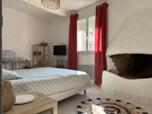 une chambre avec un lit et une fenêtre avec des rideaux rouges dans l'établissement Spacieux T2 climatisé - Près du centre ville, à Narbonne