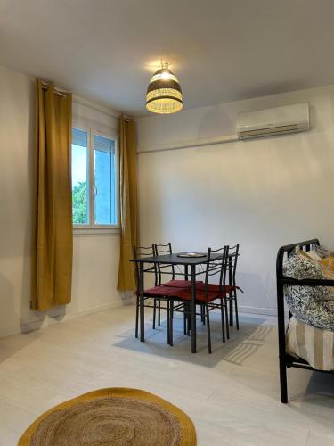 une salle à manger avec une table et des chaises et une fenêtre dans l'établissement Spacieux T2 climatisé - Près du centre ville, à Narbonne