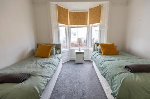 two beds sitting in a room with a window at 5 Star Homes- Free Wifi & Parking, Contractor & family friendly in Pallion
