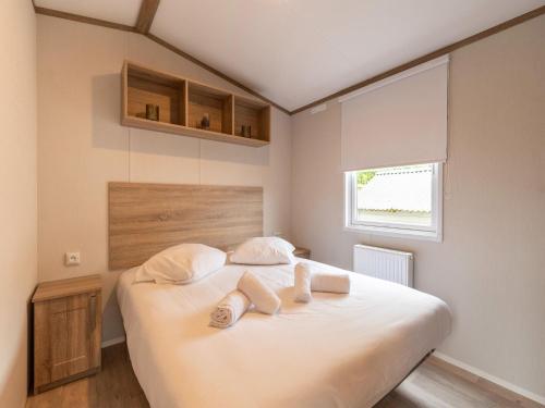 a bedroom with a large white bed with two pillows at Chalet in De Haan near Sandy Beaches in De Haan