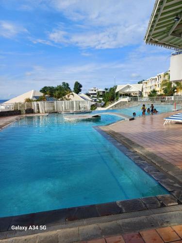 una piscina con acqua blu in un resort di la tartane a La Trinité