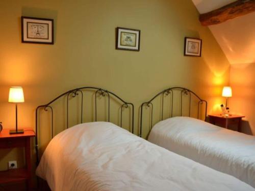 a bedroom with two beds and two lamps on the wall at Holiday Home in Chilleurs near Château in Chilleurs-aux-Bois
