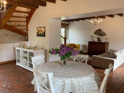 - un salon avec une table ornée de fleurs violettes dans l'établissement Holiday Home in Chilleurs near Château, à Chilleurs-aux-Bois