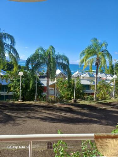 a view of a resort with palm trees and the ocean at la tartane in La Trinité