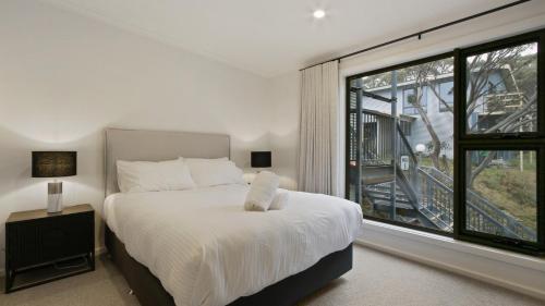 a bedroom with a bed and a large window at Higgi Drive 6 in Mount Hotham