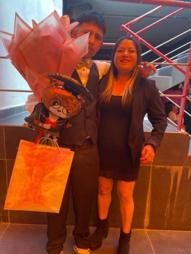 Un hombre y una mujer de pie junto a un hombre disfrazado. en La rumba, en Ciudad de México