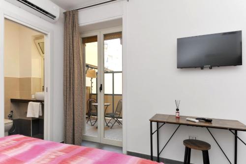 una camera da letto con un letto, una scrivania e una TV di MaryGiò a Salerno
