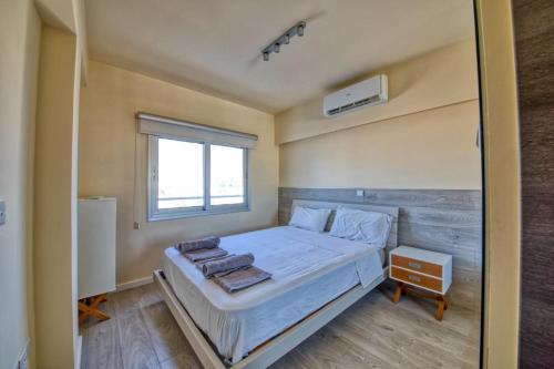 a bedroom with a large bed and a window at Limassol Molos Hawaii Royal - Front-line 2 bedroom in Limassol