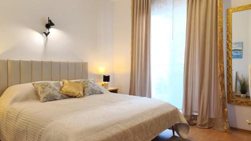 a bedroom with a bed with a mirror and a window at Avalena Rooms in Zadar