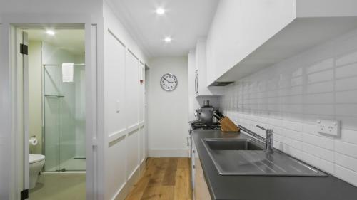 a kitchen with a sink and a toilet and a clock at Shamrock 1 in Mount Hotham