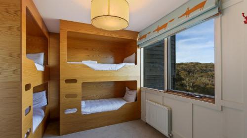 a room with two bunk beds and a window at Shamrock 1 in Mount Hotham