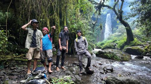 a group of people standing in front of a waterfall at Aranka Tempasan in Sangyang