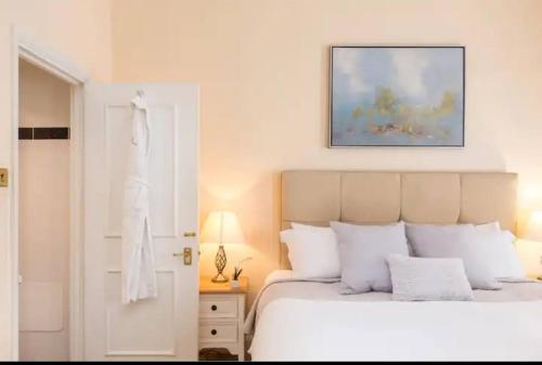 a bedroom with a white bed and a picture on the wall at London Guest Room in London
