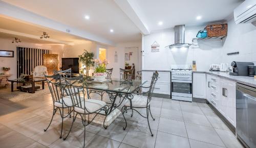 a kitchen and dining room with a table and chairs at Swan Valley Willow Cottage in Upper Swan
