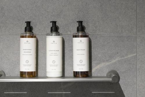 three bottles of soap sitting on a shelf at TRYP Adelaide by Wyndham in Adelaide