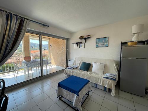 d'un salon avec un canapé et un balcon. dans l'établissement BANYULS-SUR-MER : T2, loggia et parking à 2 pas de la plage - FR-1-309-39, à Banyuls-sur-Mer
