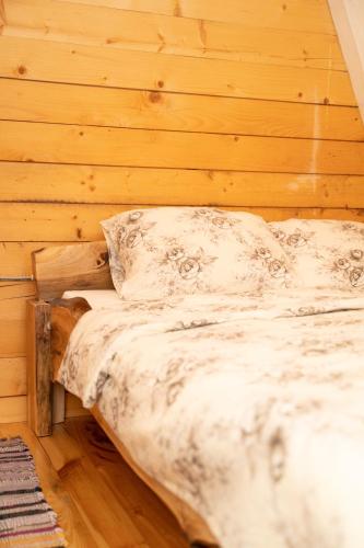 a bed in a room with a wooden wall at Eka's Village in Plav