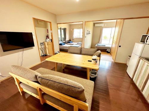 a living room with a wooden table and a kitchen at アイコニー in Miyako Island