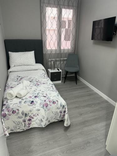 a bedroom with a bed and a television and a chair at LOGROÑO CENTRO A ESTRENAR WIFI IMPECABLe in Logroño