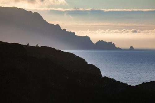 a group of people standing on a hill near the ocean at The Cliffs - A Pedrinha in Viveiro